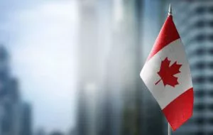 Canadian flag with skyscraper buildings in the background